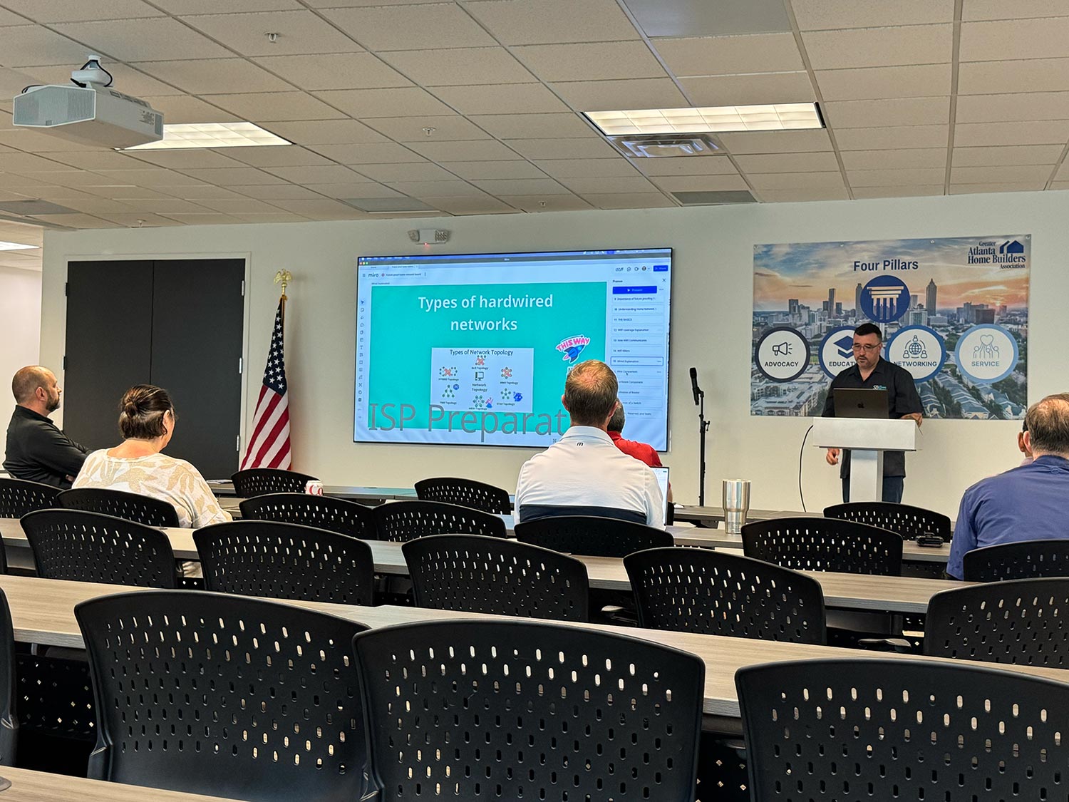 Presenter teaching about network types with slide projected on screen