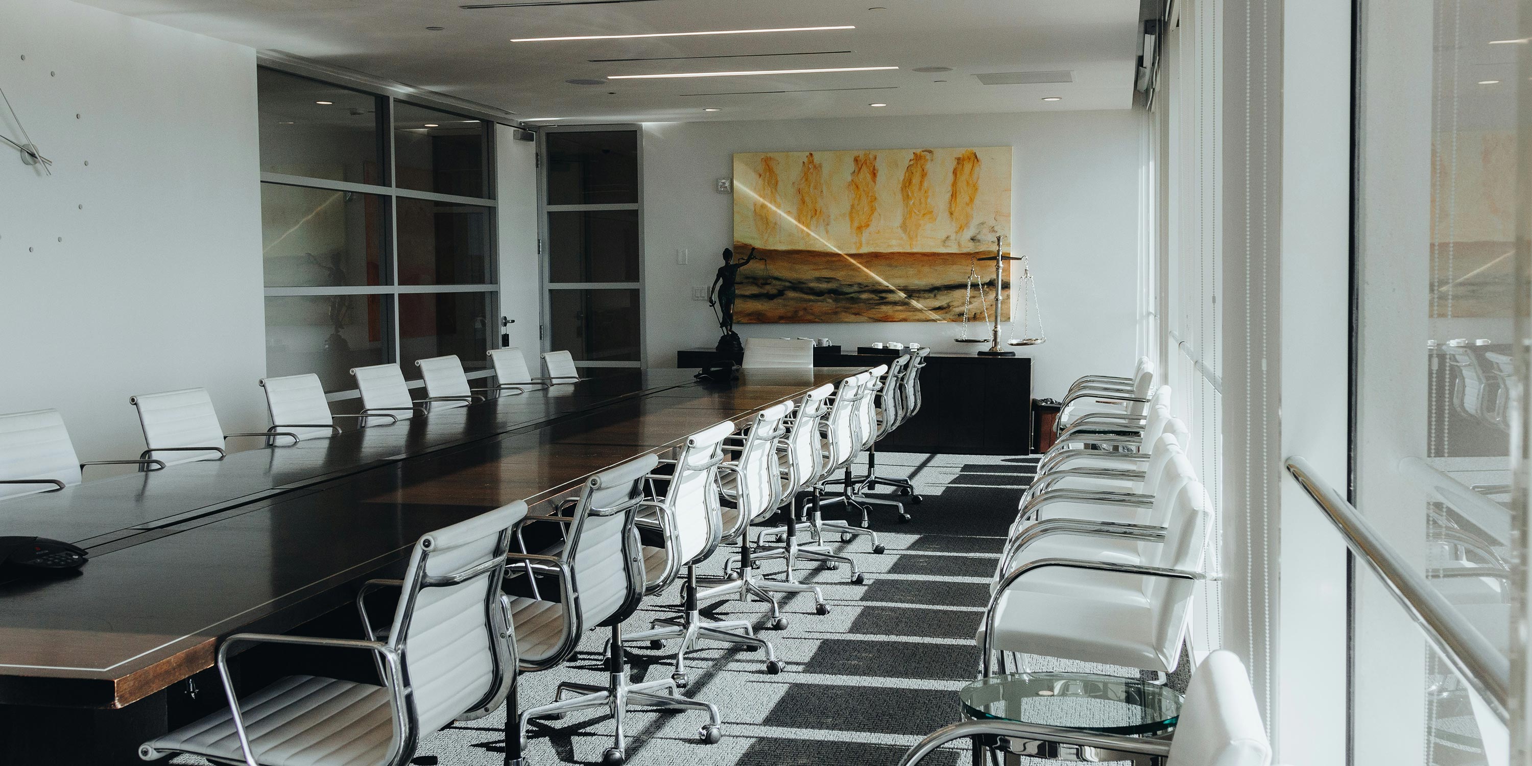Sleek boardroom with long table and white swivel chairs