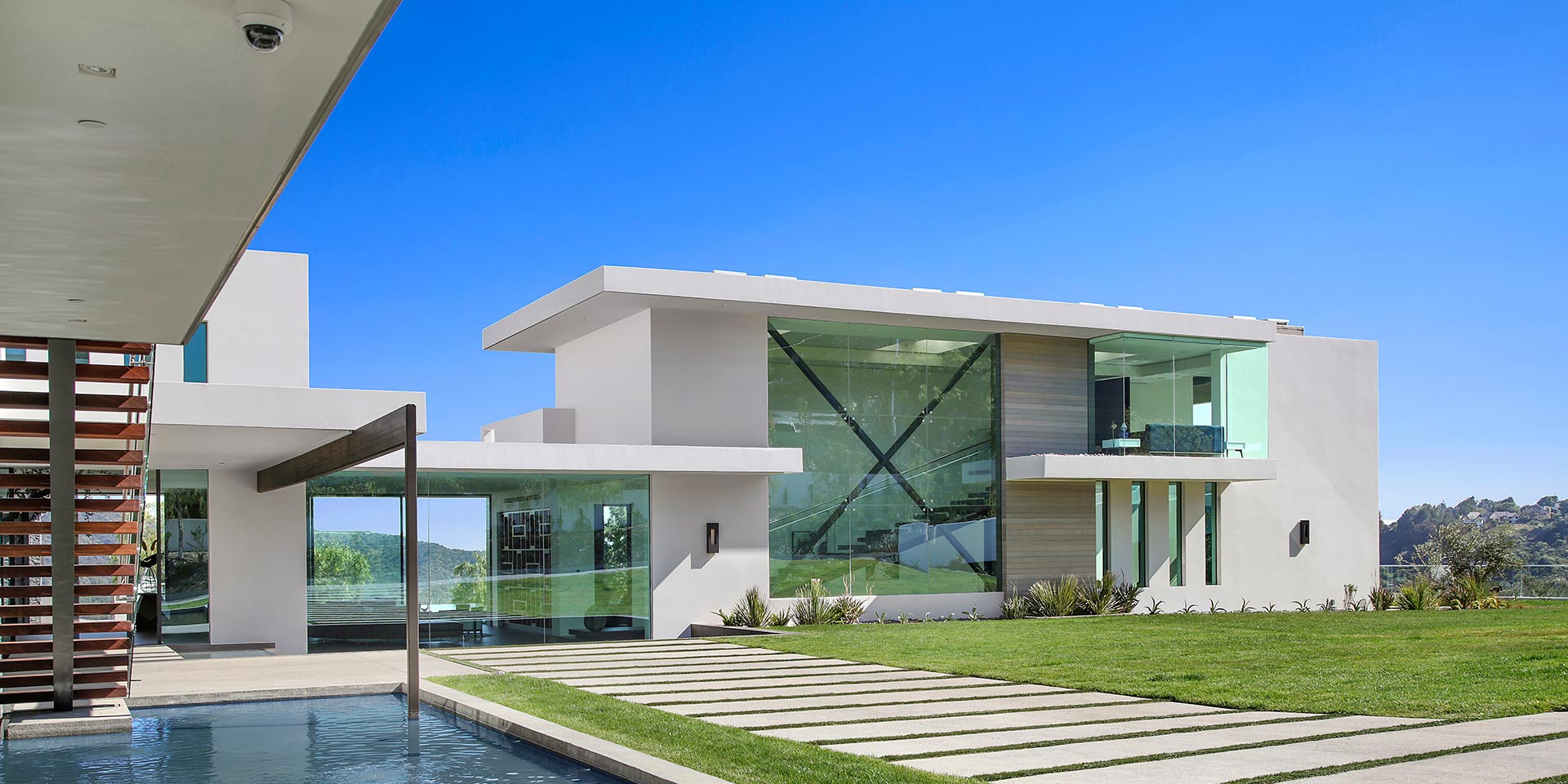 Contemporary luxury home with large glass windows and manicured lawn