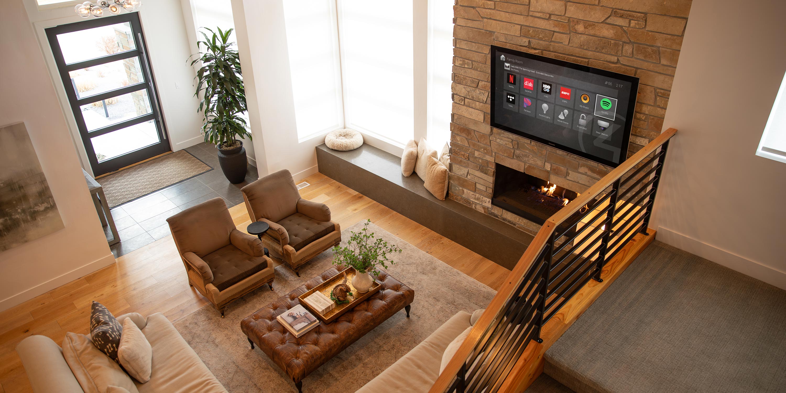 View of a spacious modern home with smart TV and fireplace from upper floor