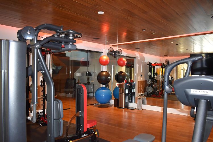 Fitness room with large equipment, medicine balls, and mirrored wall