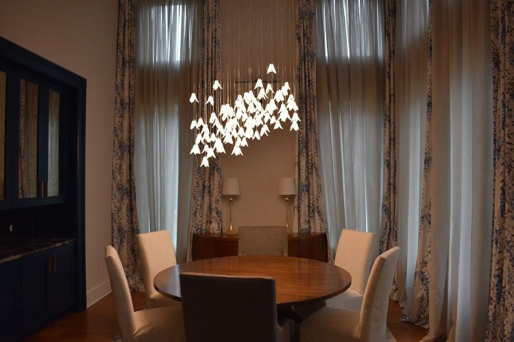 Cozy dining room with round wood table and cascading floral chandelier
