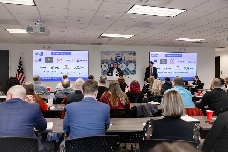 Speaker presenting at GAHBA board meeting in a packed conference room