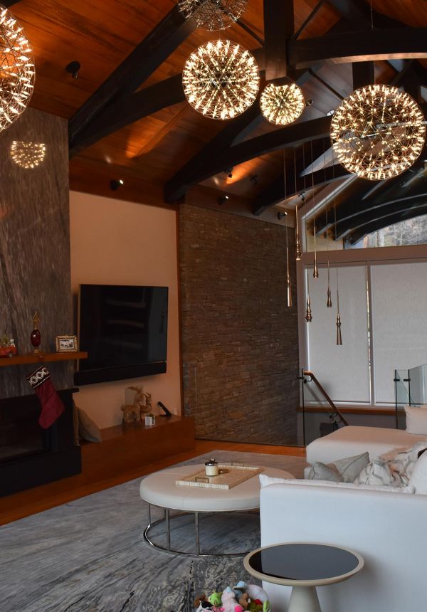 Elegant living room with modern chandelier lights and vaulted wood ceiling