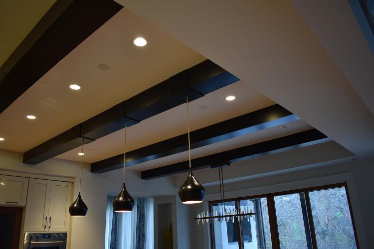 Ceiling view with dark wooden beams, pendant lights, and recessed lighting