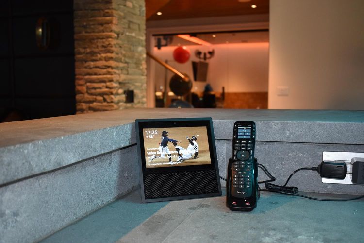 Smart display and universal remote on gray stone counter with power outlet