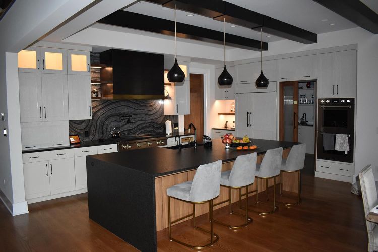 Contemporary kitchen with black island and warm white cabinet lighting
