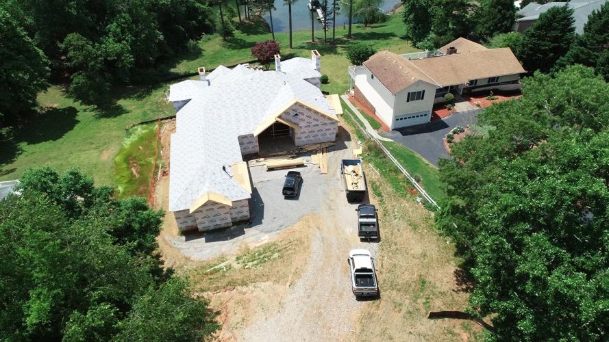 Aerial view of a house under construction beside a lake