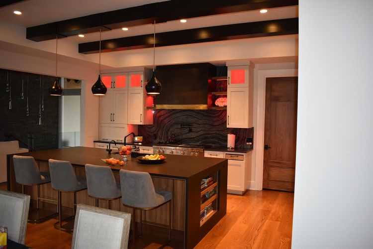 Kitchen with red accent lighting and dark wood features