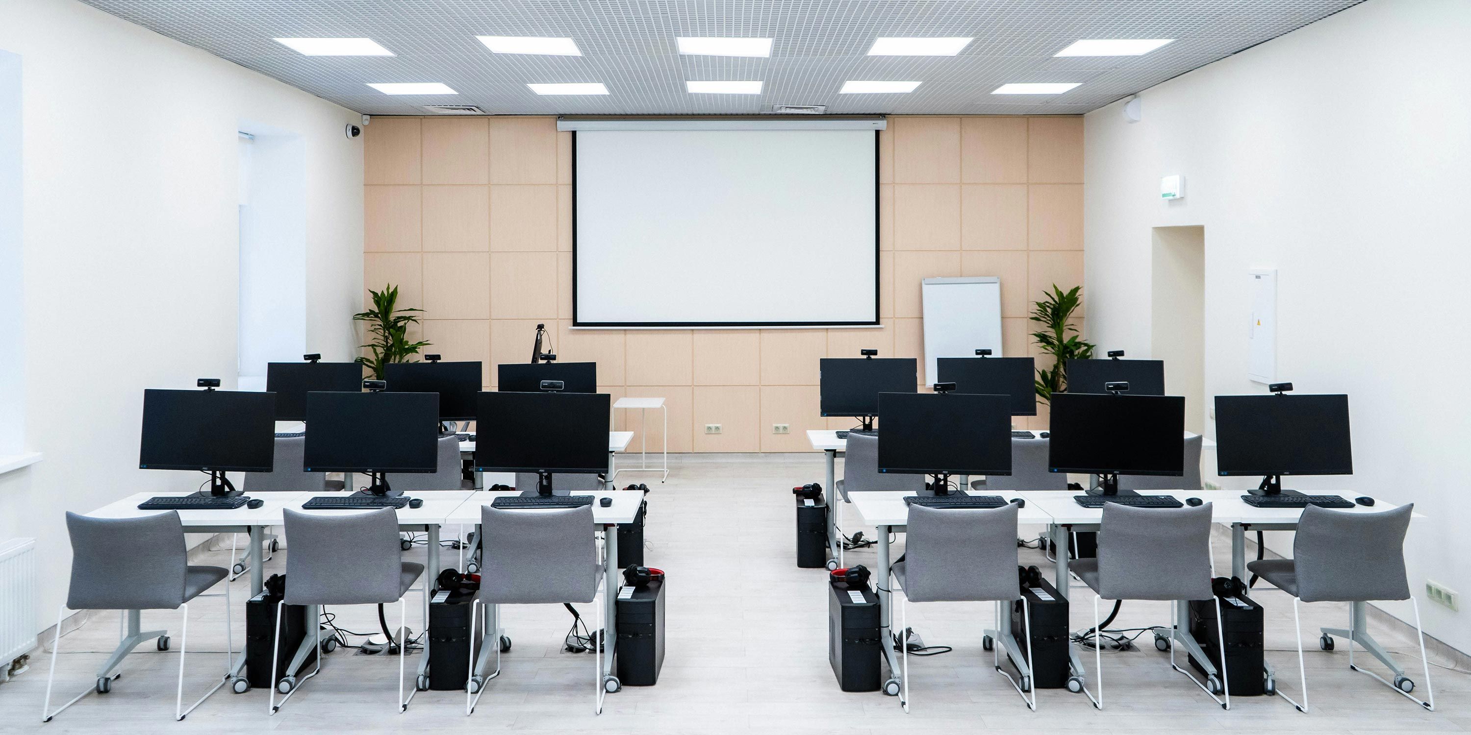 Computer-equipped training room with rows of monitors
