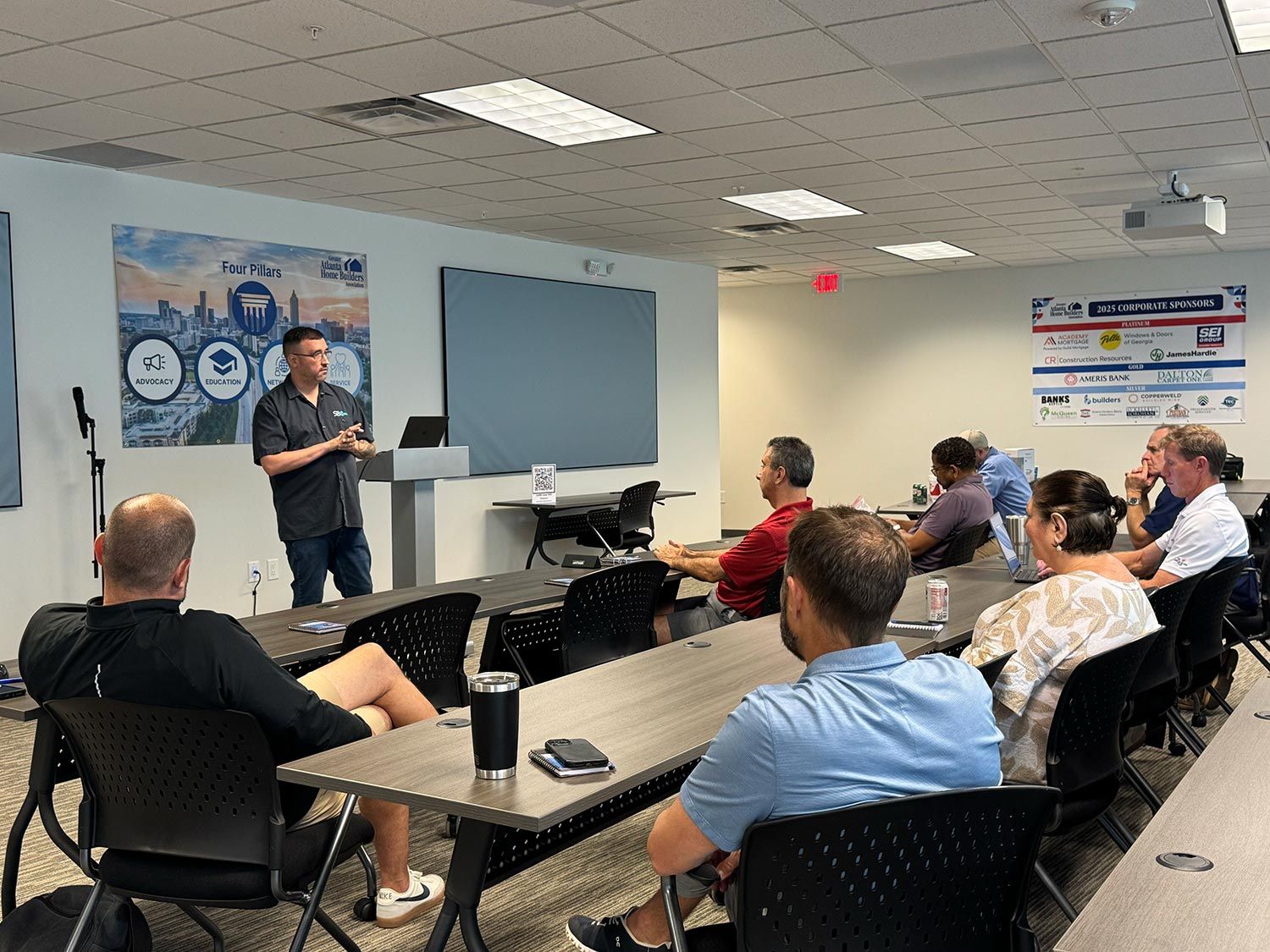 Trainer presenting in front of Four Pillars poster during an educational session
