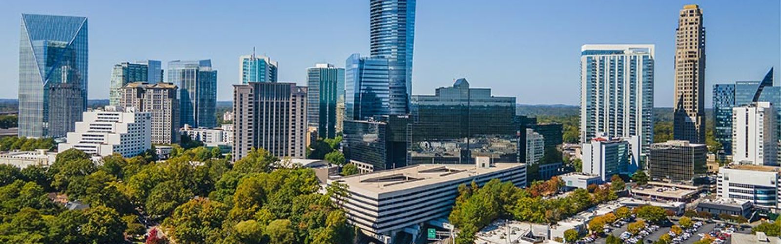 Aerial view of a modern city skyline surrounded by trees