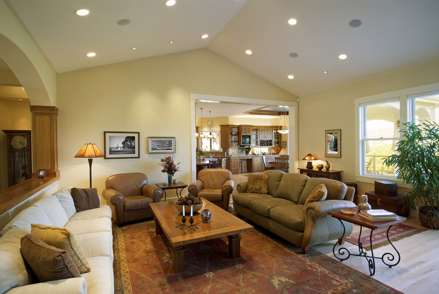 A yellow living room with brown furniture.